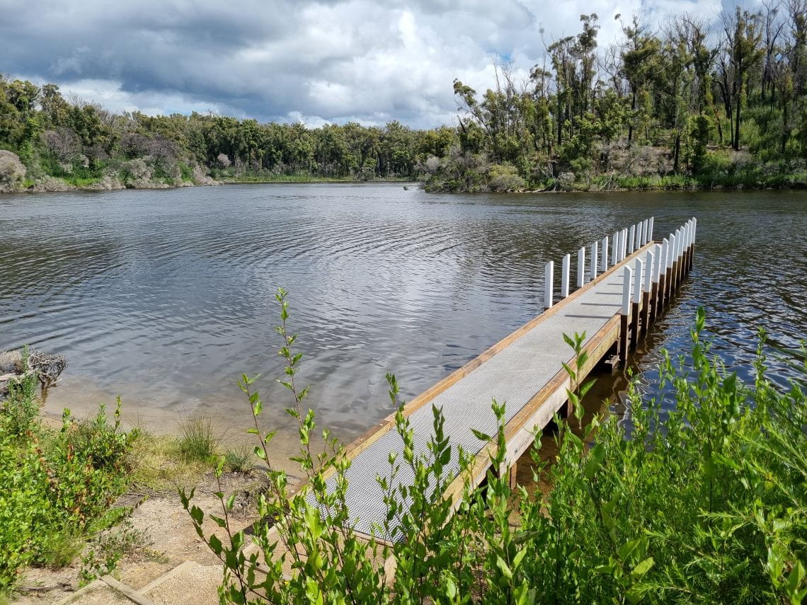 A new jetty on a body of water surrounded by native bush
