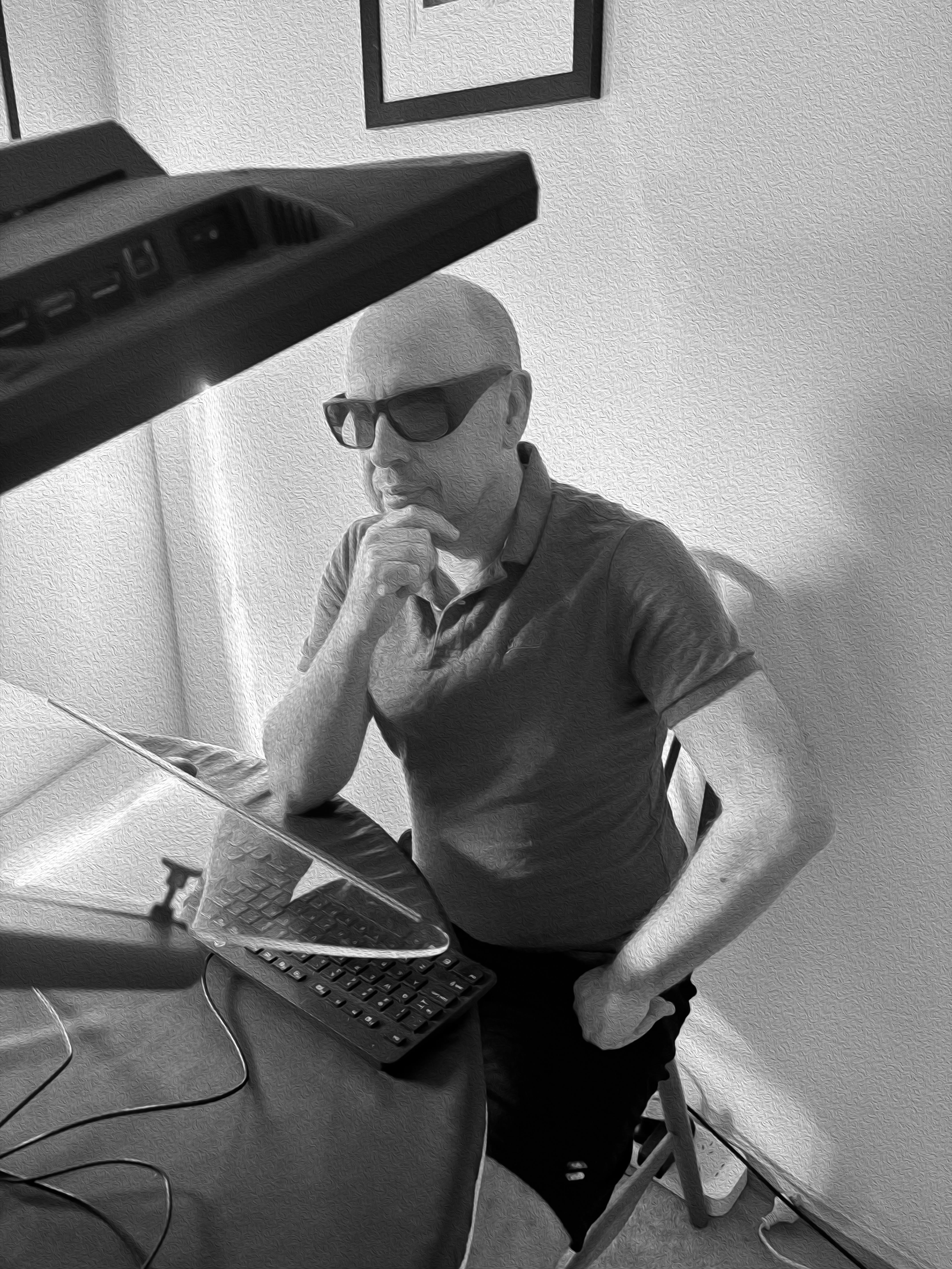 A man wearing sunglasses sitting at a specialist computer monitor to map spinifex density