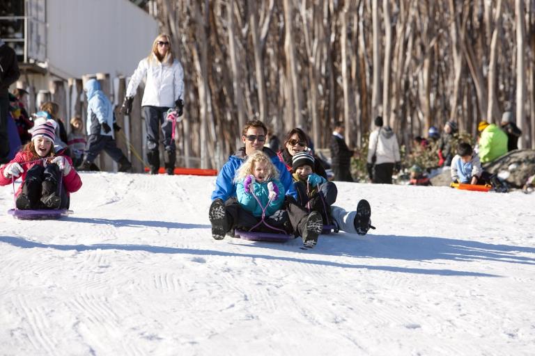 Family tobogganing down Lake Mountain