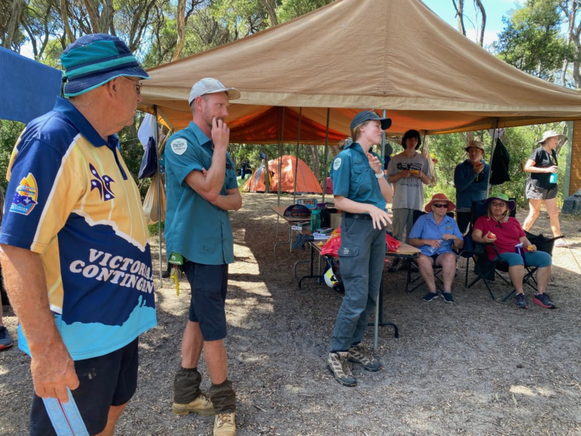 Two rangers and a scouts leader speaking towards a crowd