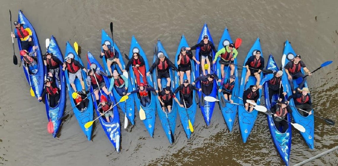 Birds eye view of 26 participants in 13 kayaks on the Yarra River, Wurundjeri Country.