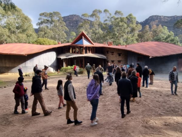 Groups of attendees walking towards the smoke facing Brambuk for the Smoking Ceremony