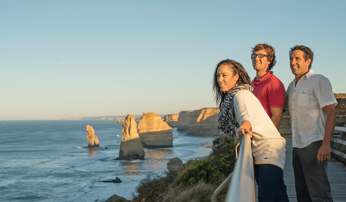Three friends enjoy a view of the Twelve Apostles, Port Campbell National Park