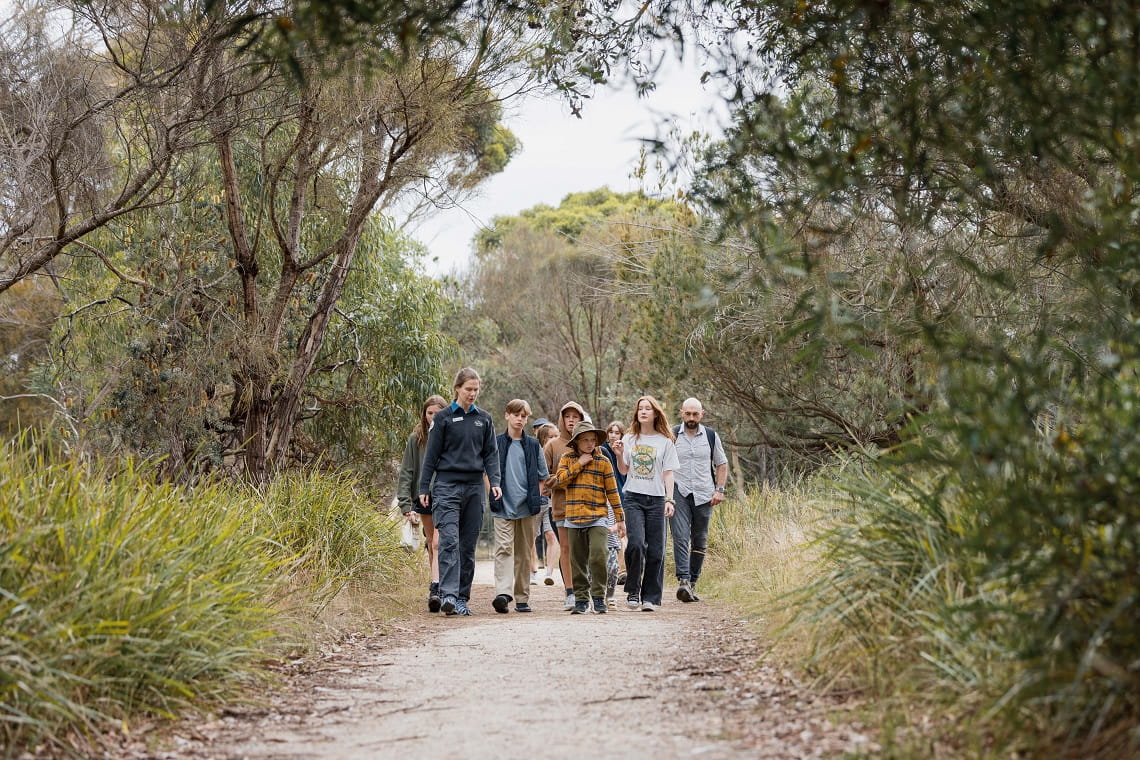 A ranger leads a group of junior rangers along a nature trail in Ocean Grove