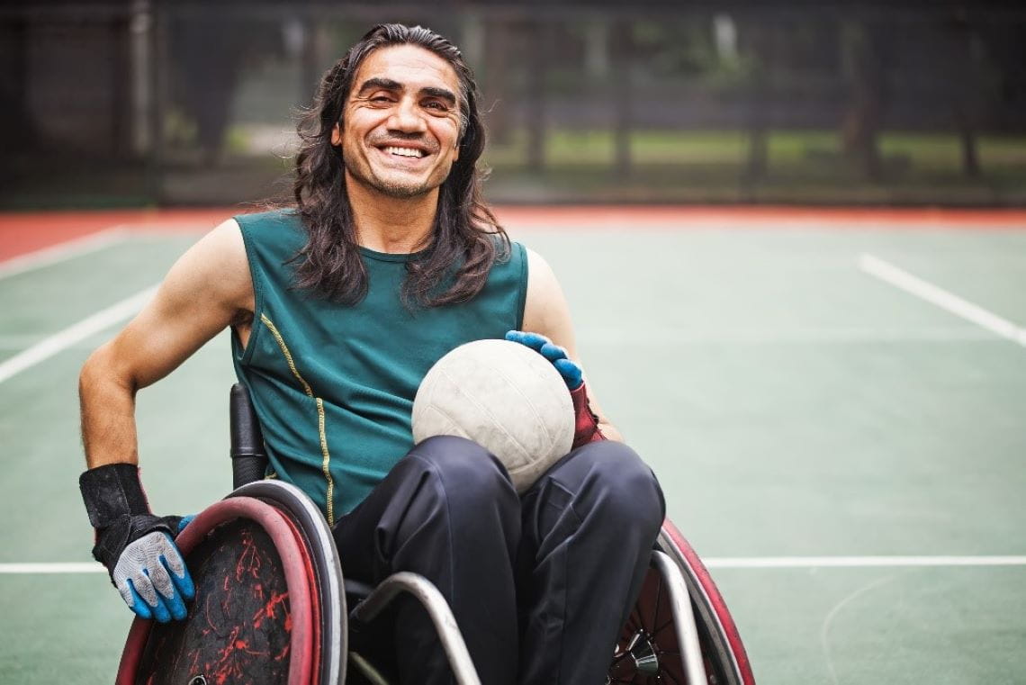 Picture of a smiling man in a wheelchair