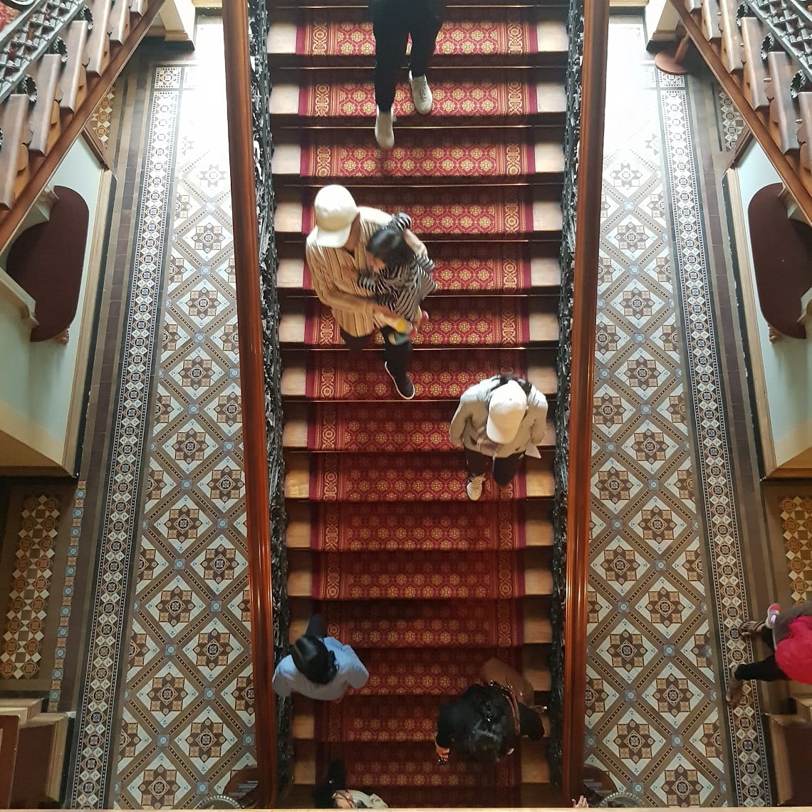 Aerial view of people walking down an old and grand staircase