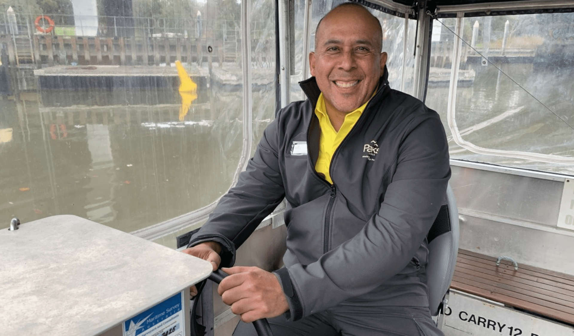 Close up image of Carlos driving a Parks Victoria vehicle, the river in the background