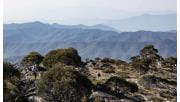 A woman hikes to the top of Mt Cobbler with spectacular views of the High Country in the background.