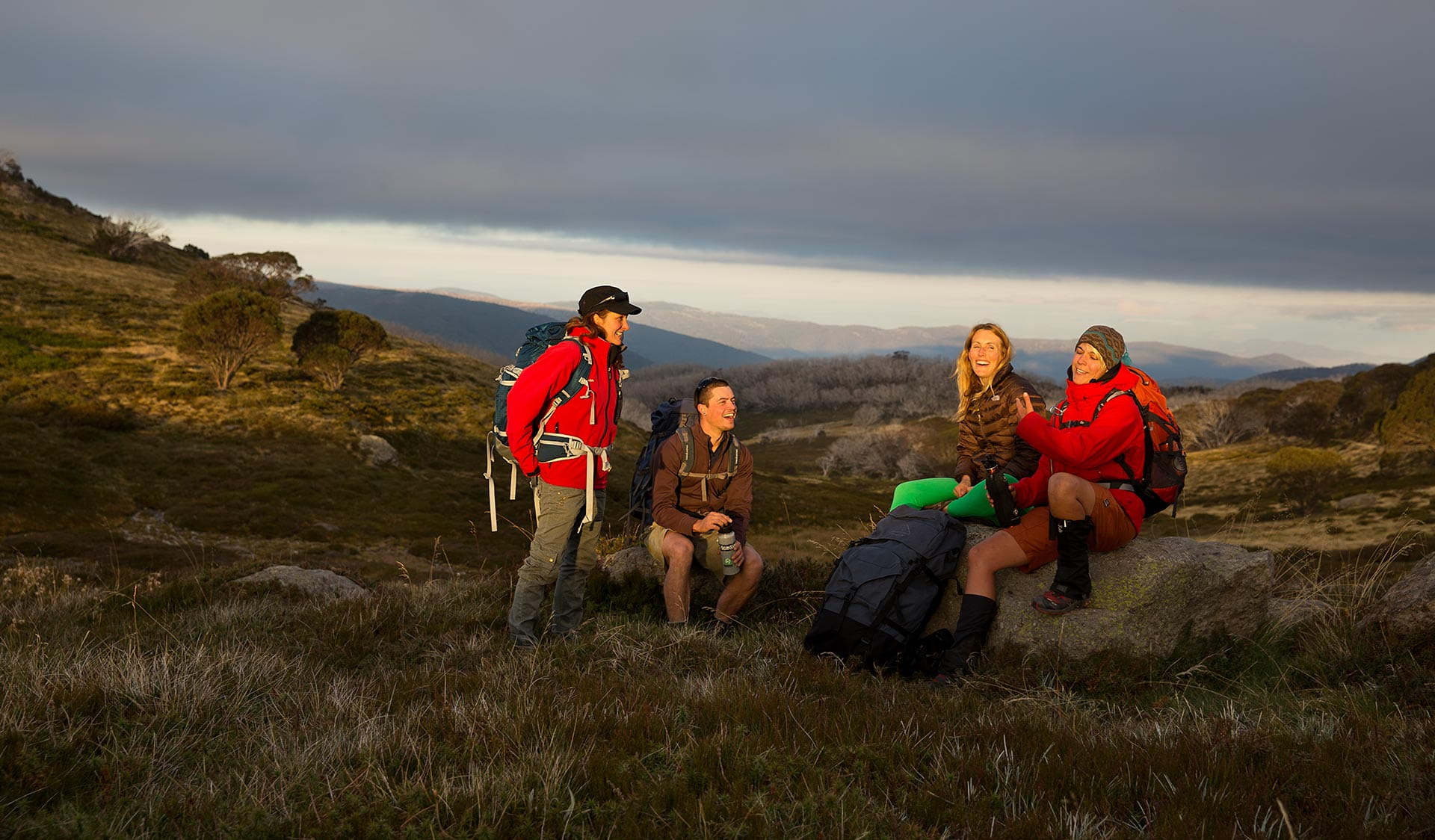 Three friends stop for a quick drink late in the afternoon on their walk from Hotham to Falls Creek.