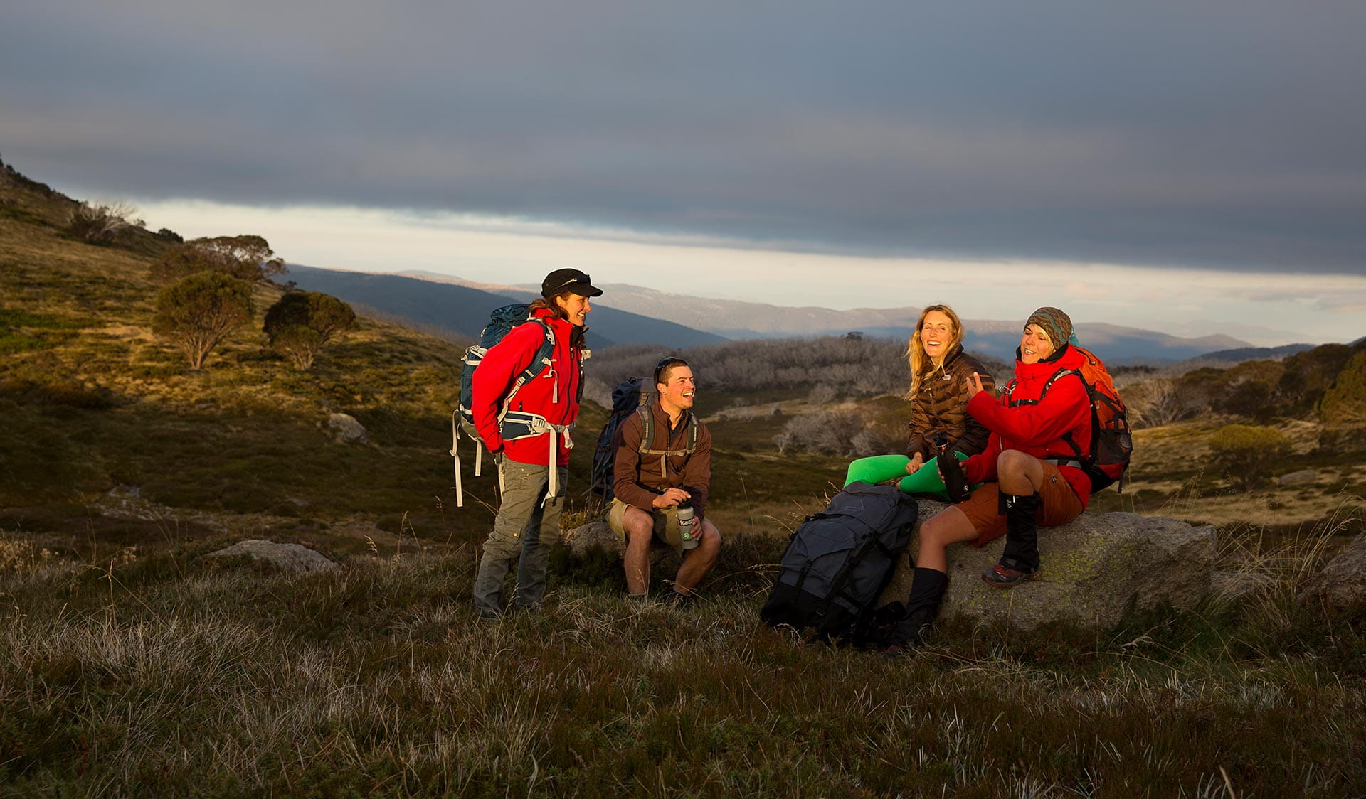 Four friends stop for a later afternoon break on the Falls to Hotham Alpine Crossing. 