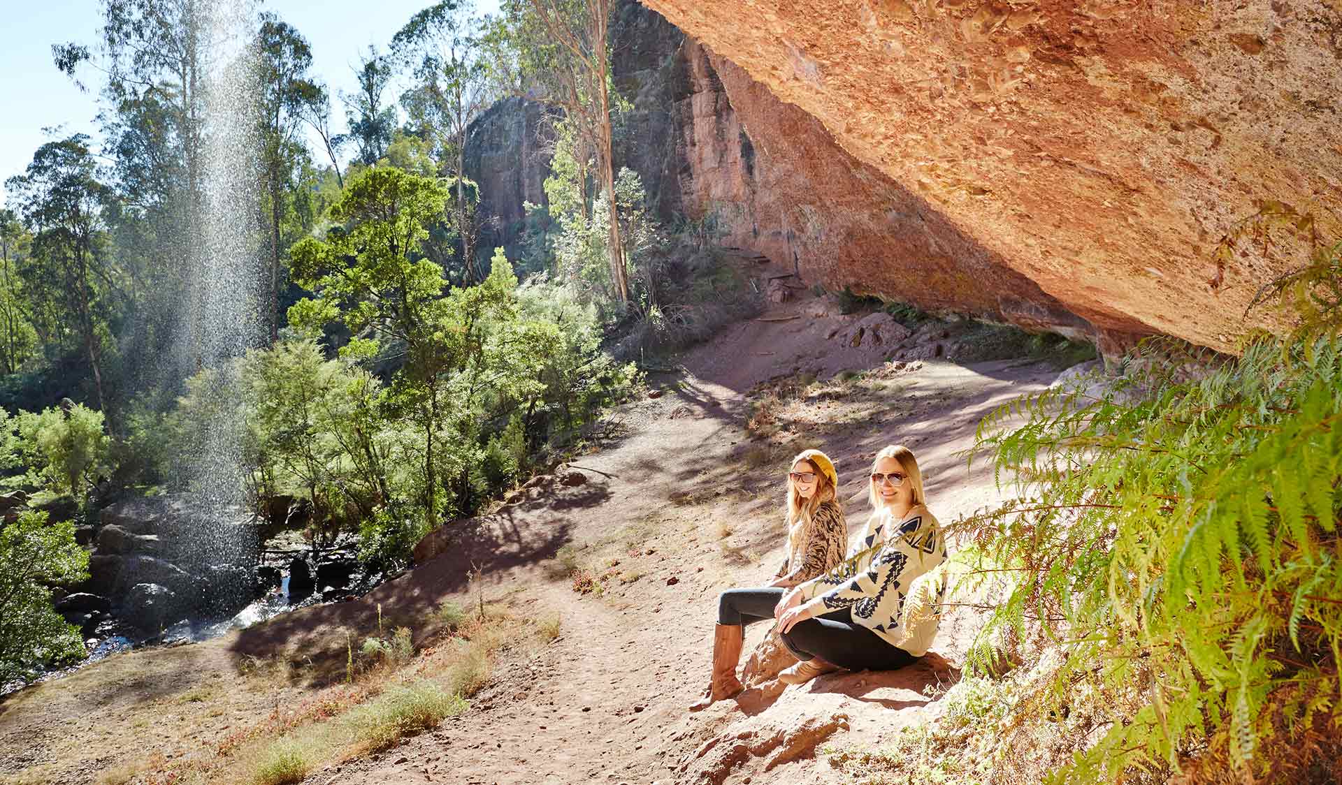 Two women sit beside the ephemeral Paradise Falls located near the headwaters of the King River in the Alpine National Park. 