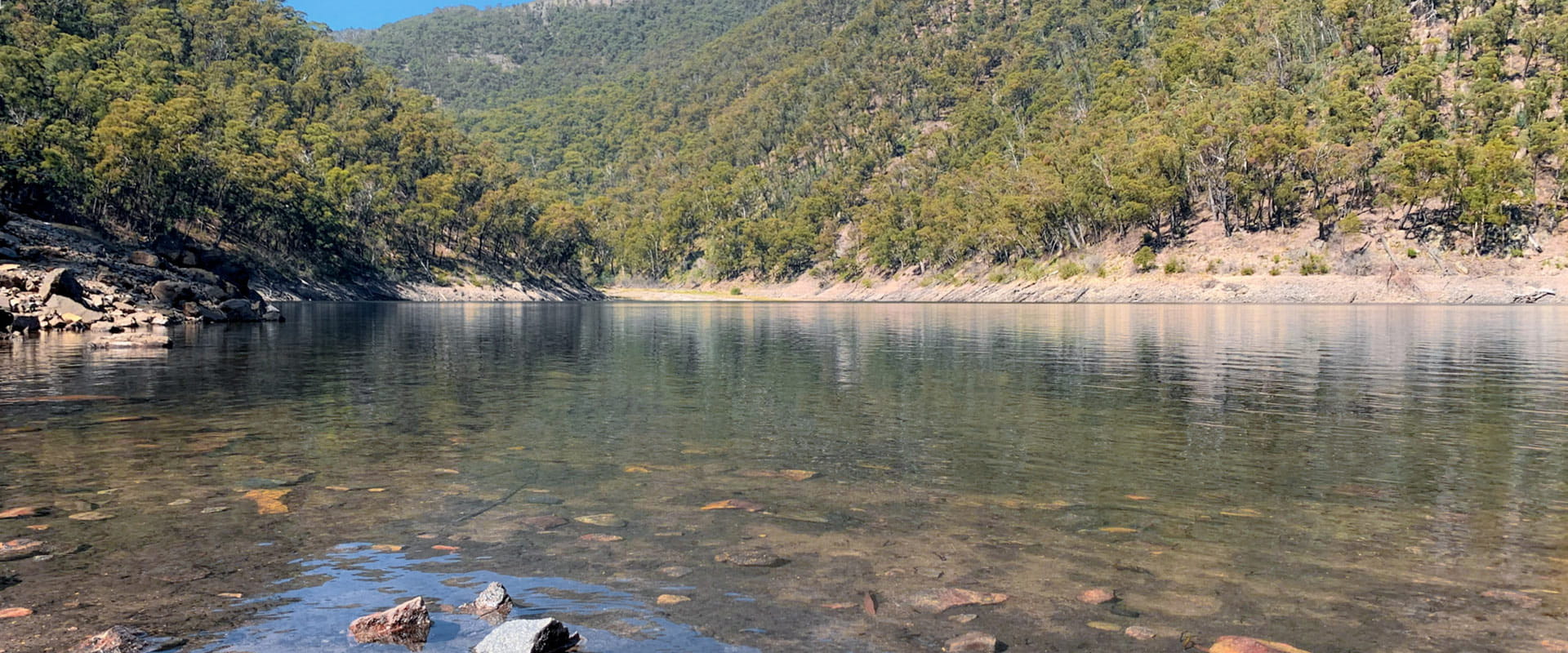A rocky lake surrounded by steep mountains.