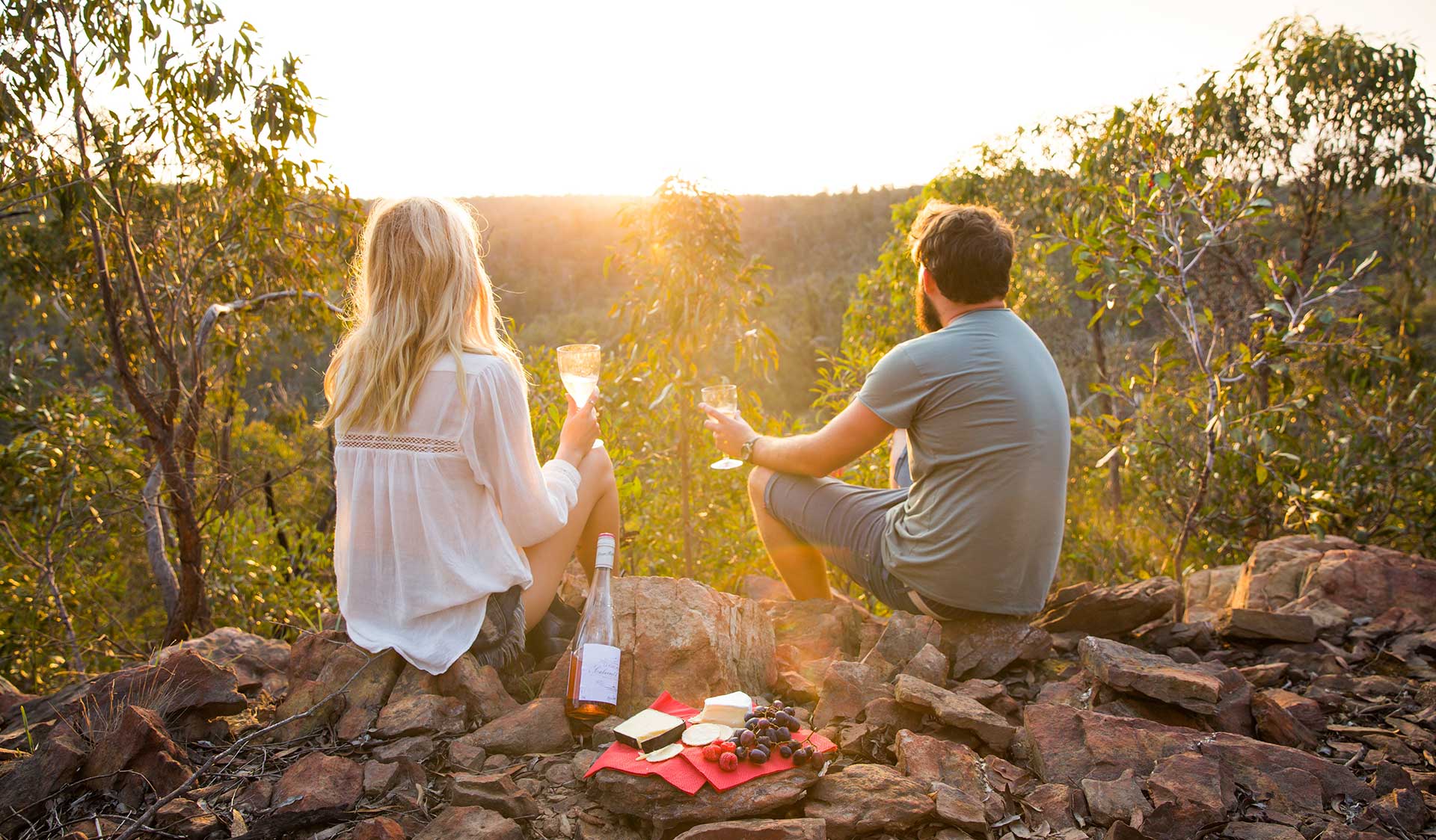 A couple enjoy a sunset picnic in the Brisbane Ranges National Park. 