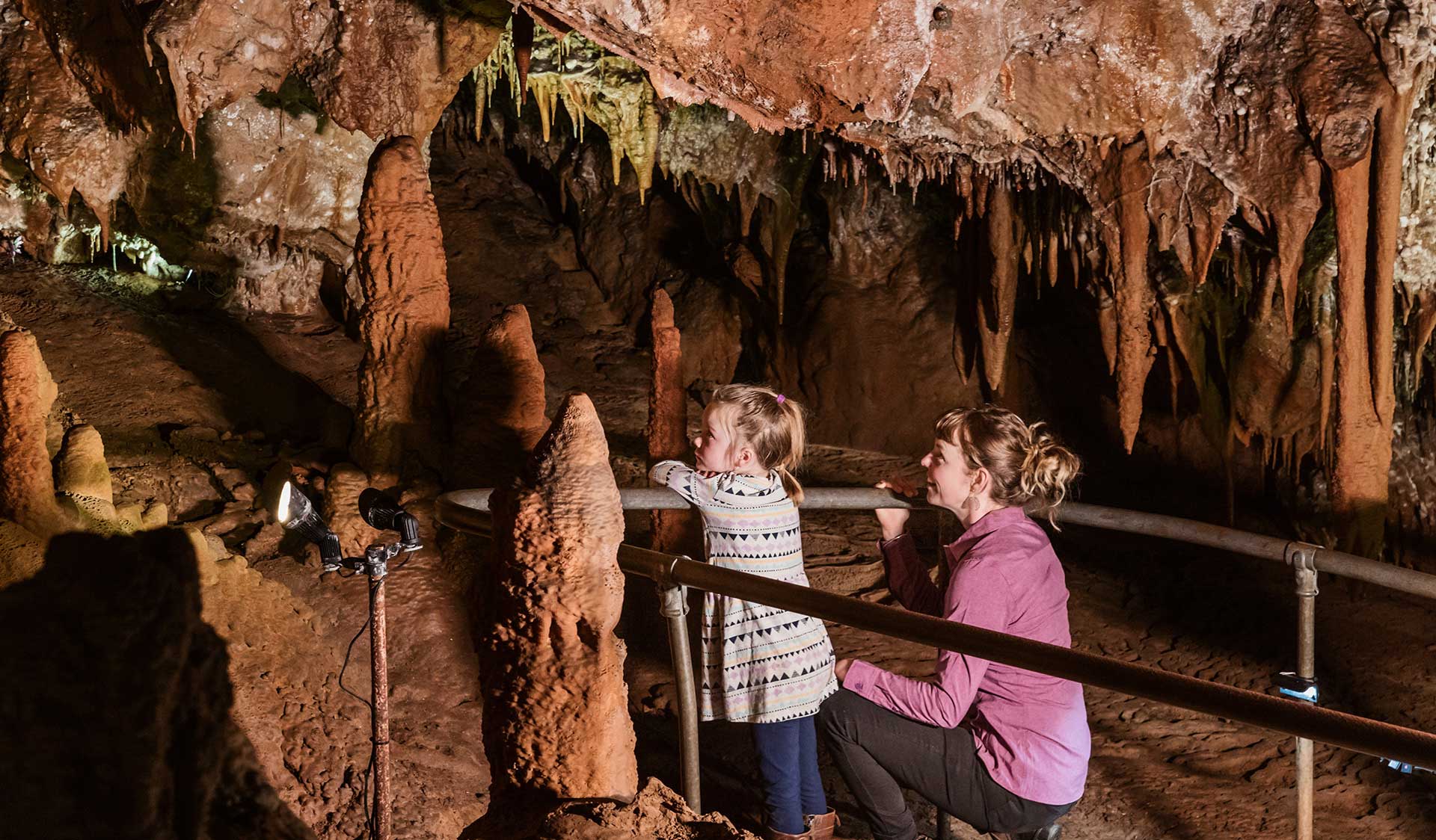 Mother and young daughter look at the rock formations in the Fairy Cave at Buchan Caves Reserve.