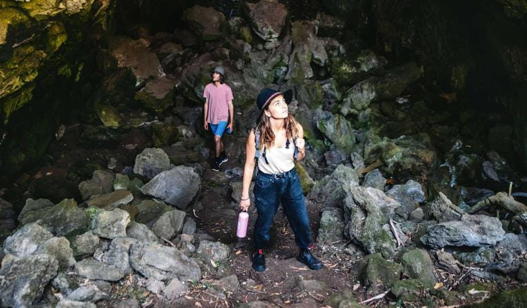 A young couple walk through a cave in Budj Bim National Park