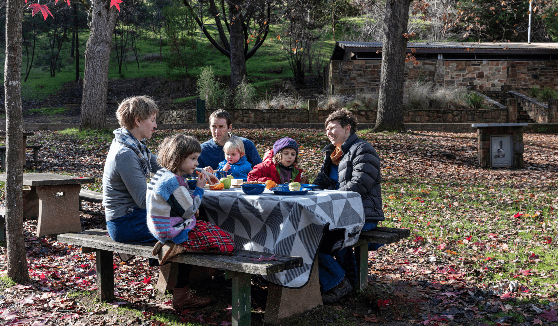 A family enjoys an autumn picnic at Vaughan Springs in Castlemaine Diggings National Heritage Park