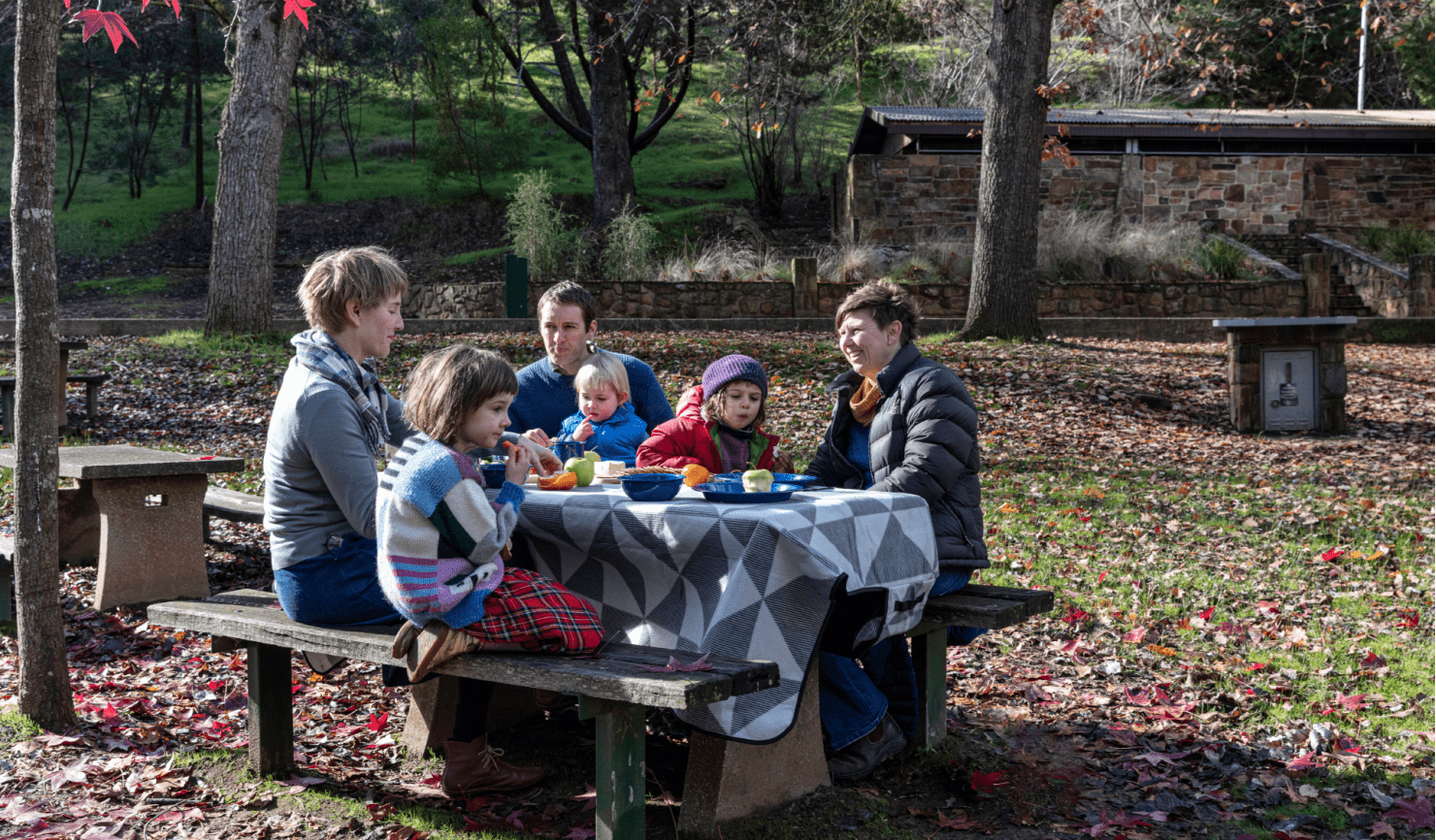 A family enjoys an autumn picnic at Vaughan Springs in Castlemaine Diggings National Heritage Park
