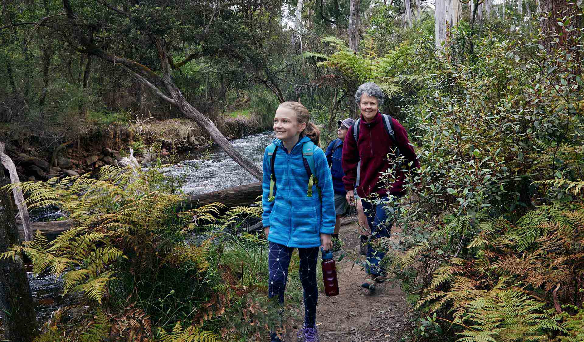 A 10 year-old girl and her grandmother walk through the lush green valley next to Little River.