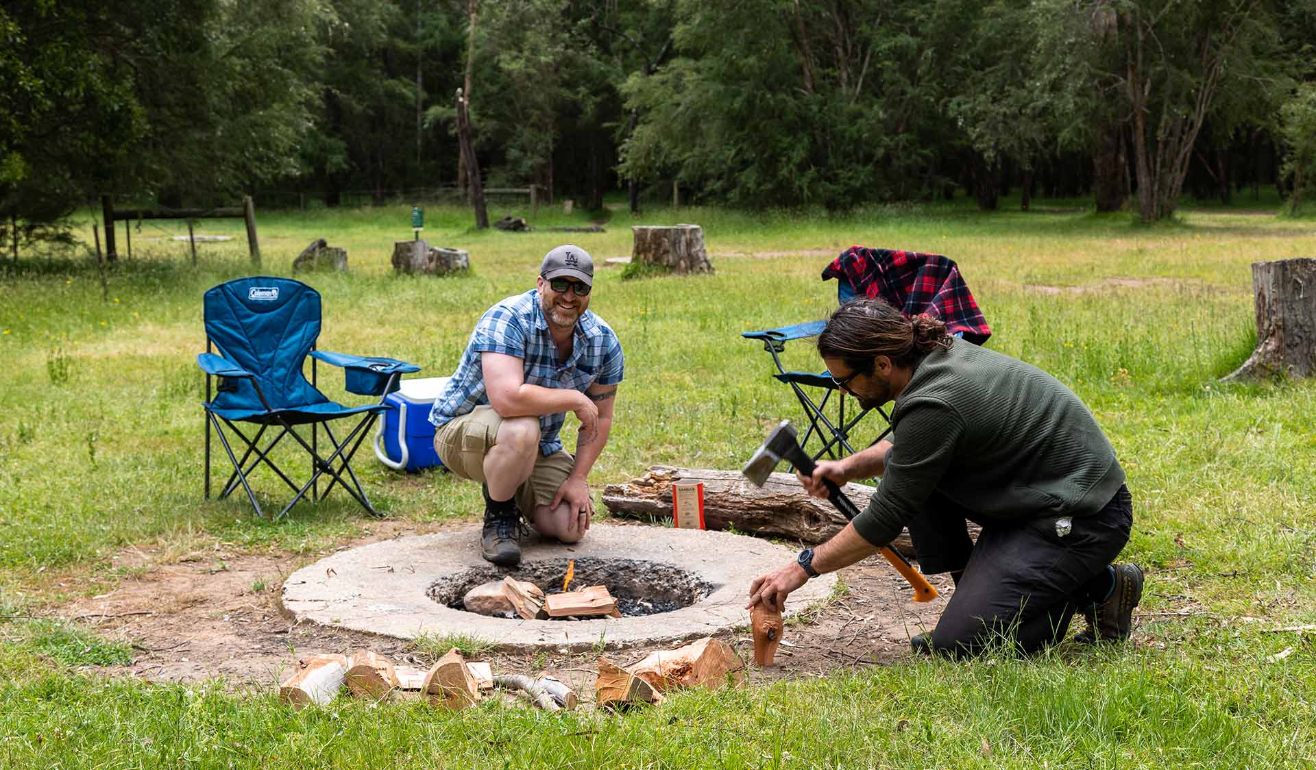 Two men huddle around a campfire fit starting a fire at Neds Gully Camping Area in the Cathedral Range State Park