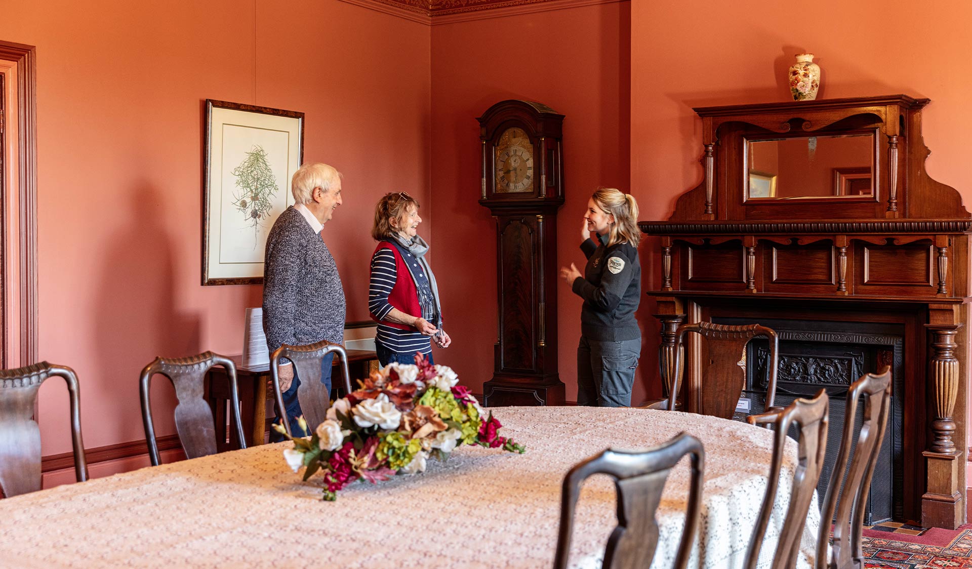 A retired couple walk chat with a ranger in the dining room of Coolart Homestead