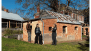 A Parks Victoria Ranger speaks to a couple outside an old building in Coolart Heritage Area