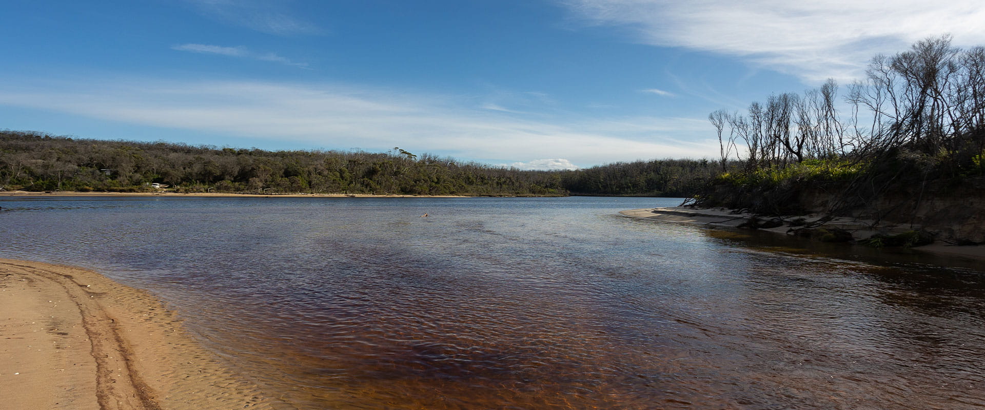 A large estuarine body of water with a sandy bank in the lower left corner.