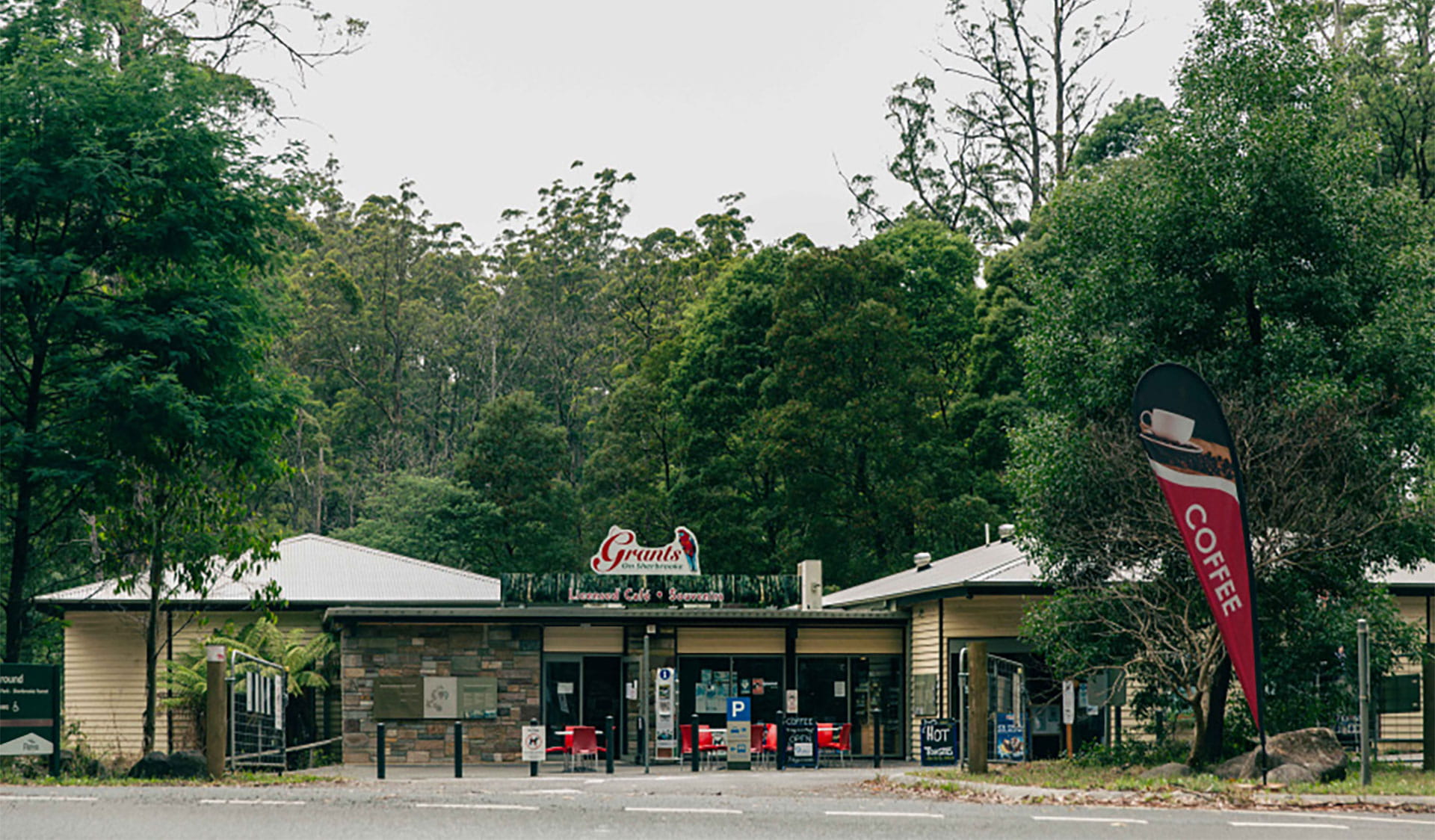 A woman and a man walking away from a waterfall.