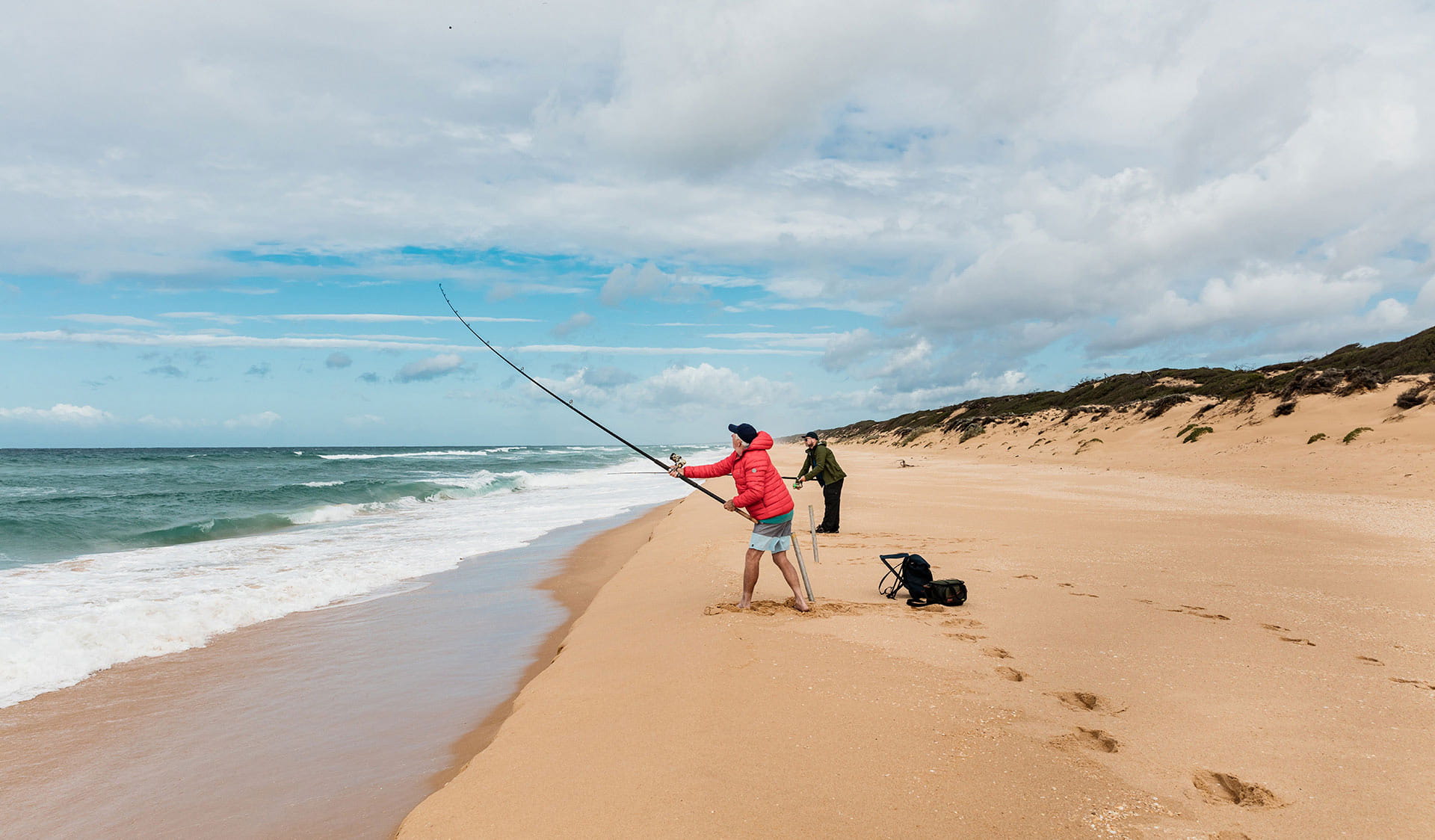 Two men fish along 90 mile beach.