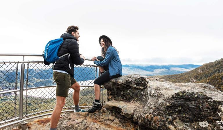 A couple in their twenties chat at the Lakeview lookout in the Grampians National Park.