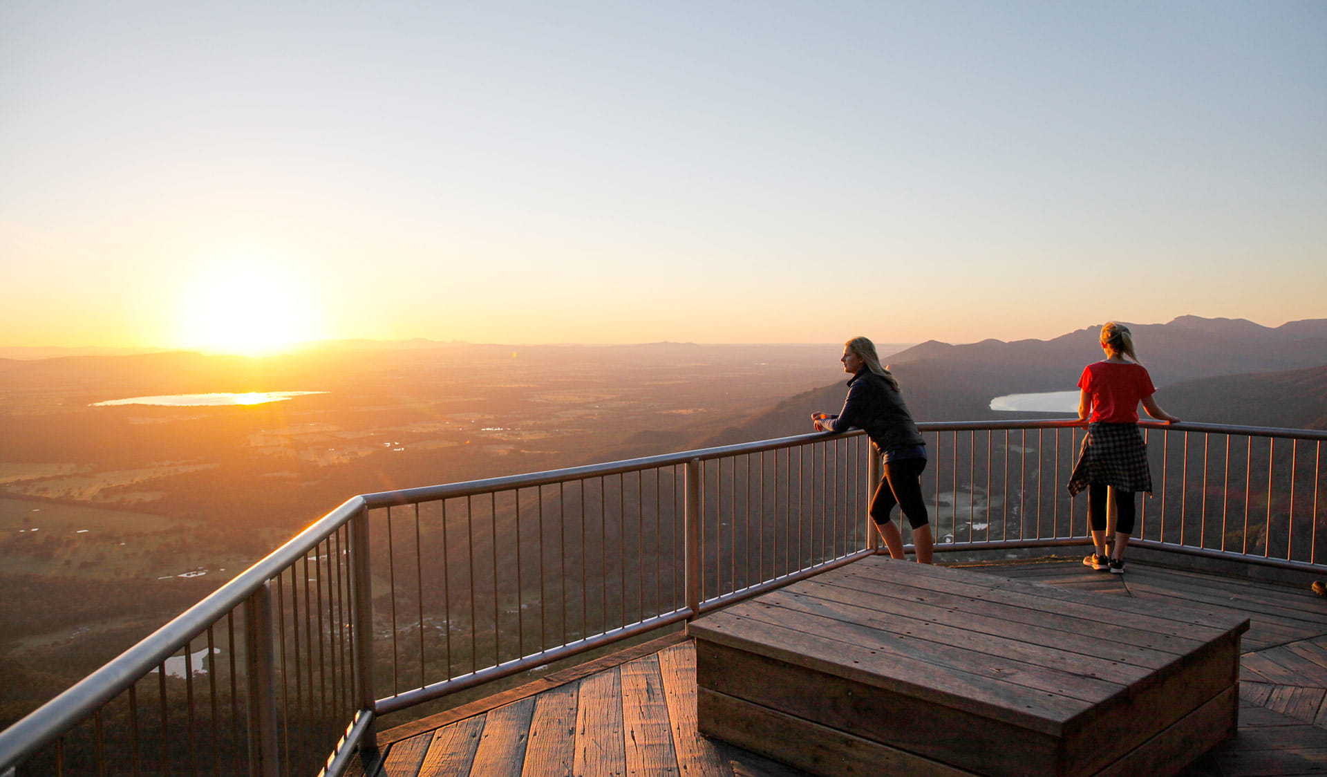Two friends take in the view from Boroka Lookout at sunset.