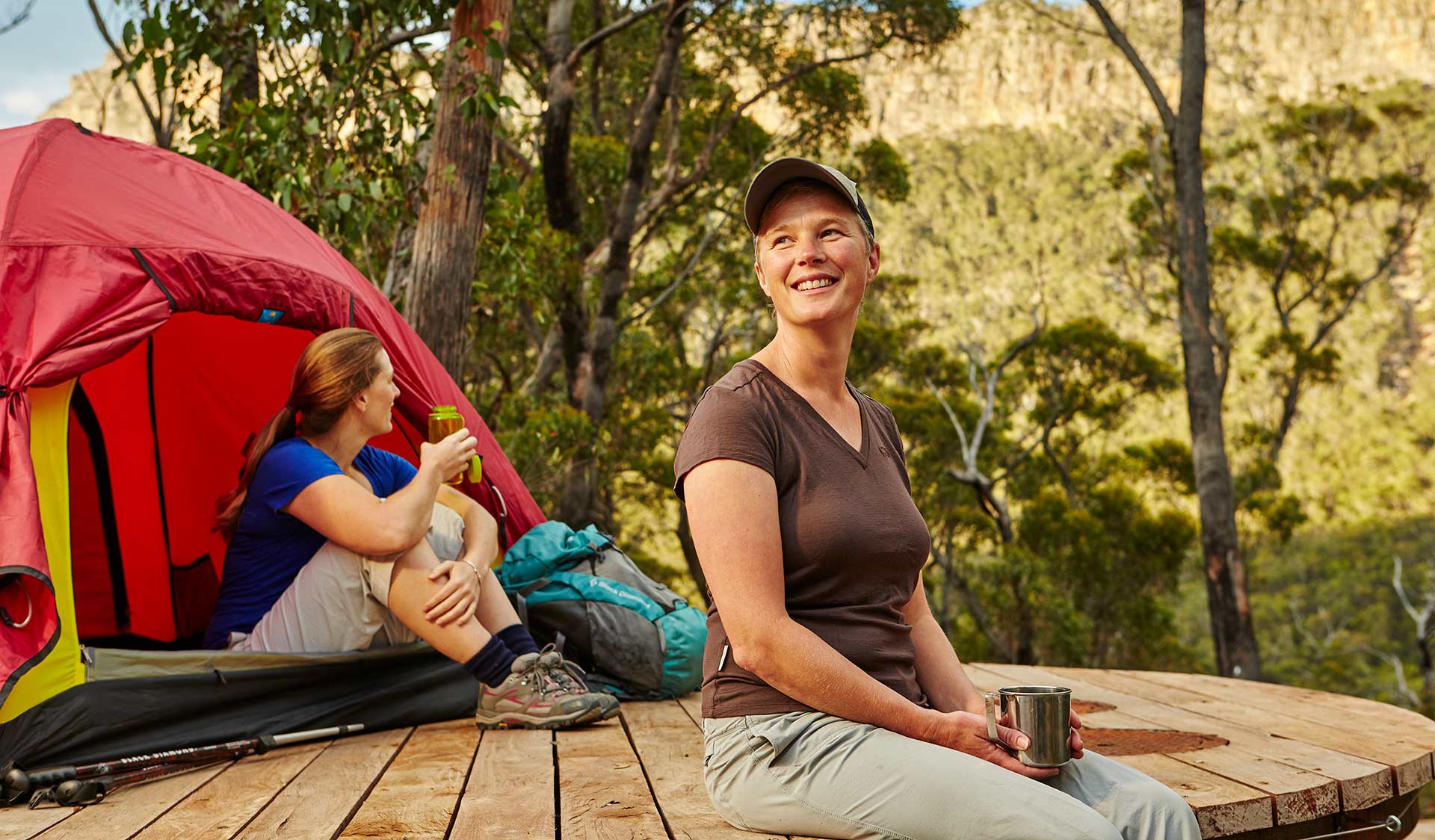 Two people sit next to their tent at Bugiga Hiker Camp on the Grampians Peaks Trail