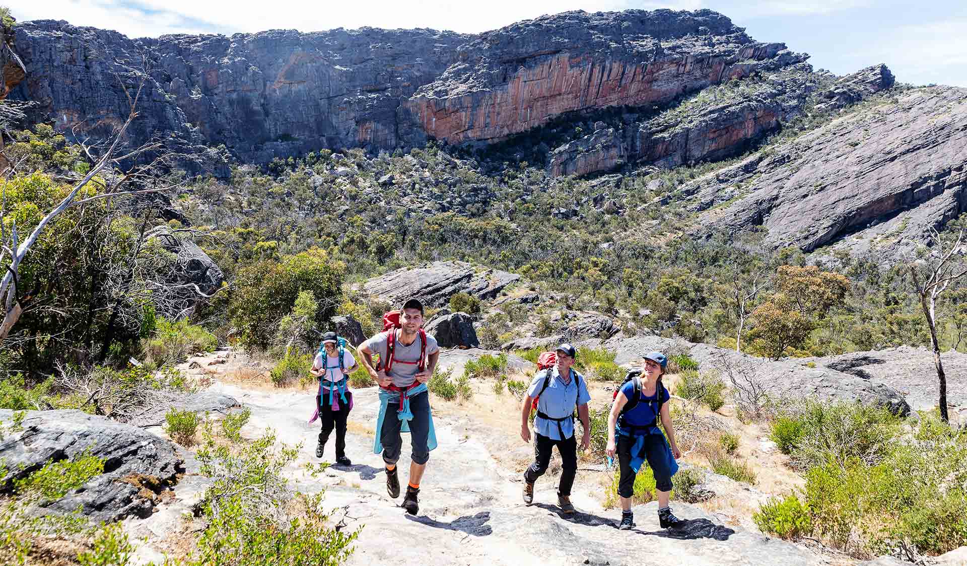 Four friends looking up at the surrounding scenery during their hike at Mount Stapylton