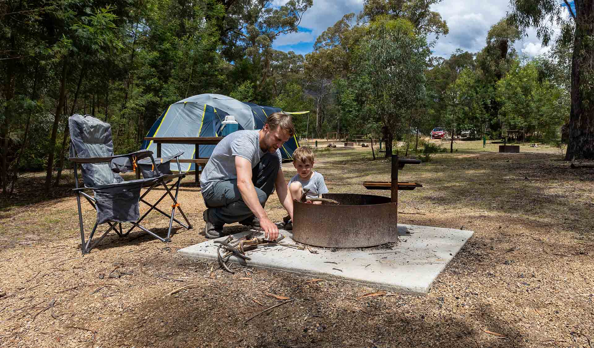 A father and young son prepare a fire in the communal fire pits at Troopers Creek Campground at the Grampians National Park