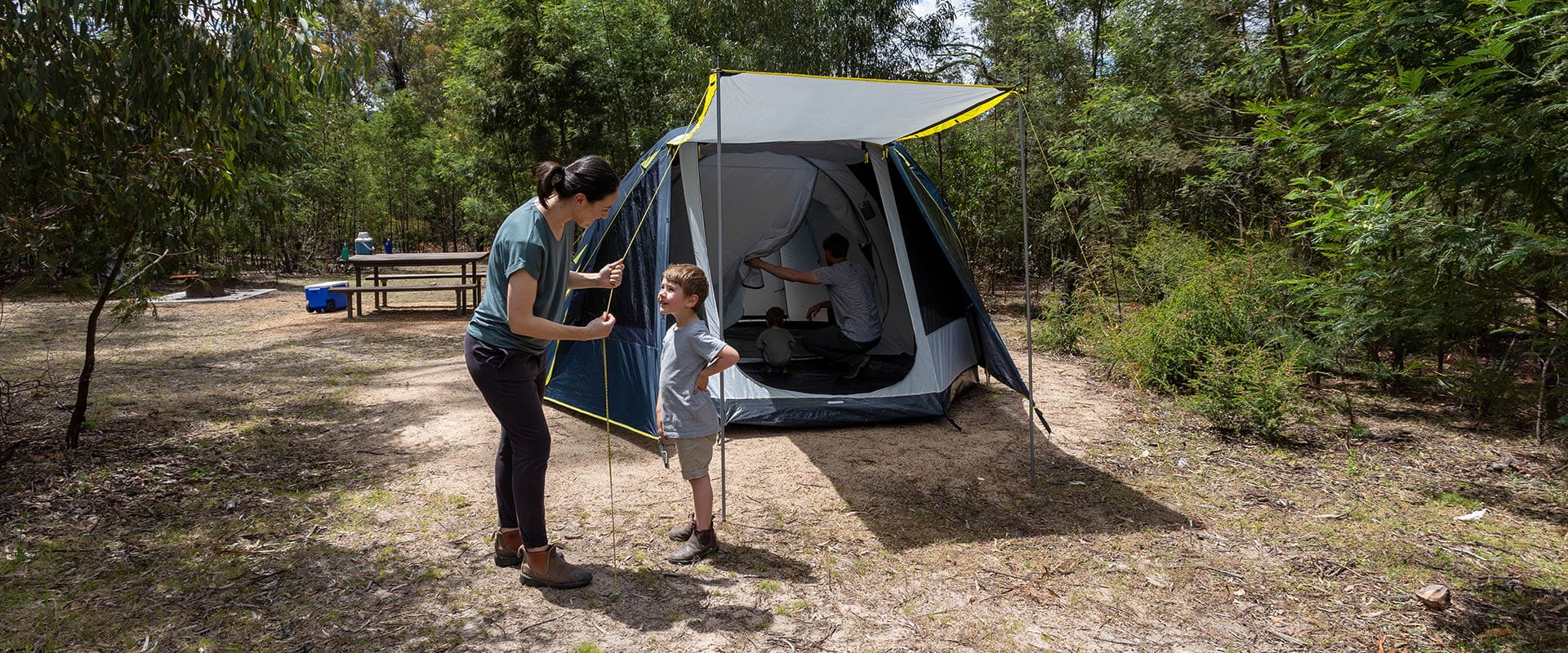 A family set up camp surrounded by bushland