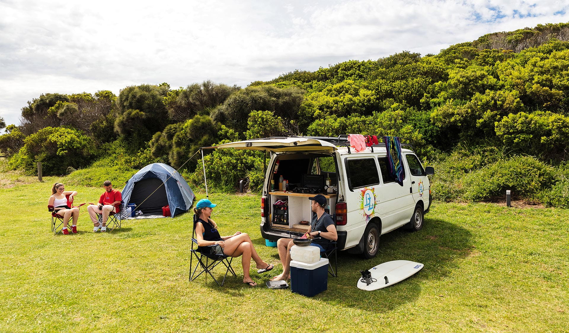 Two couples car camping on grass.