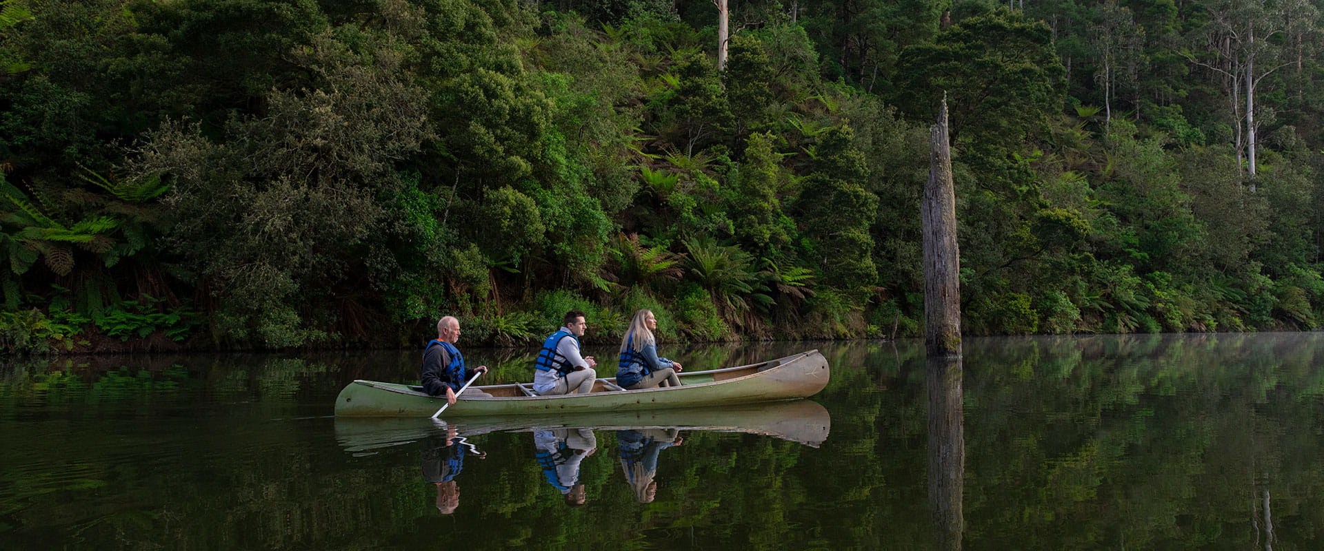 Three people in a canoe on Lake Elizabeth