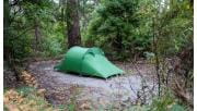 A green tent in a clearing at Elliott Ridge Campground on the Great Ocean Walk at the Great Otway National Parks