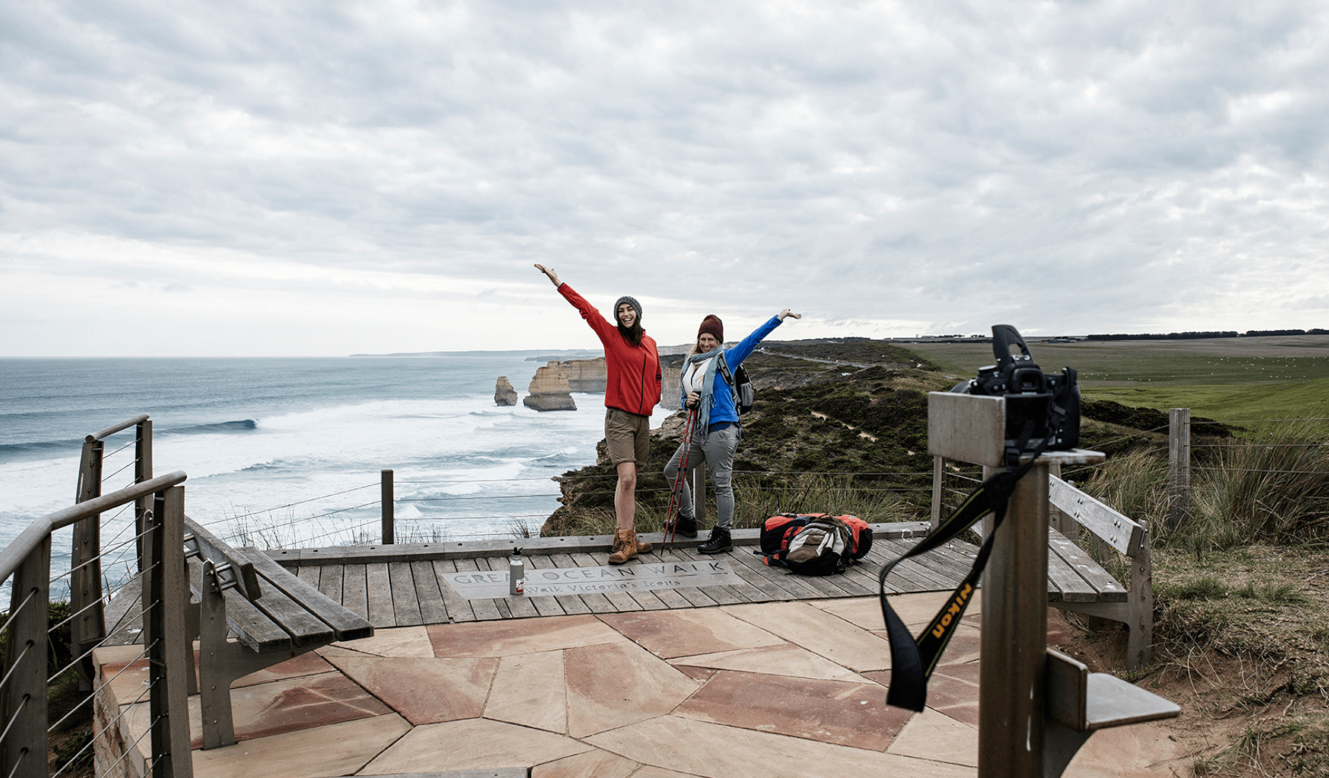 Two female hikers pose for a camera at the end of the Great Ocean Walk