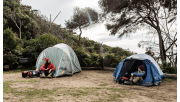 Two female hikers sit outside their tents at Blanket Bay Hike-in Campground