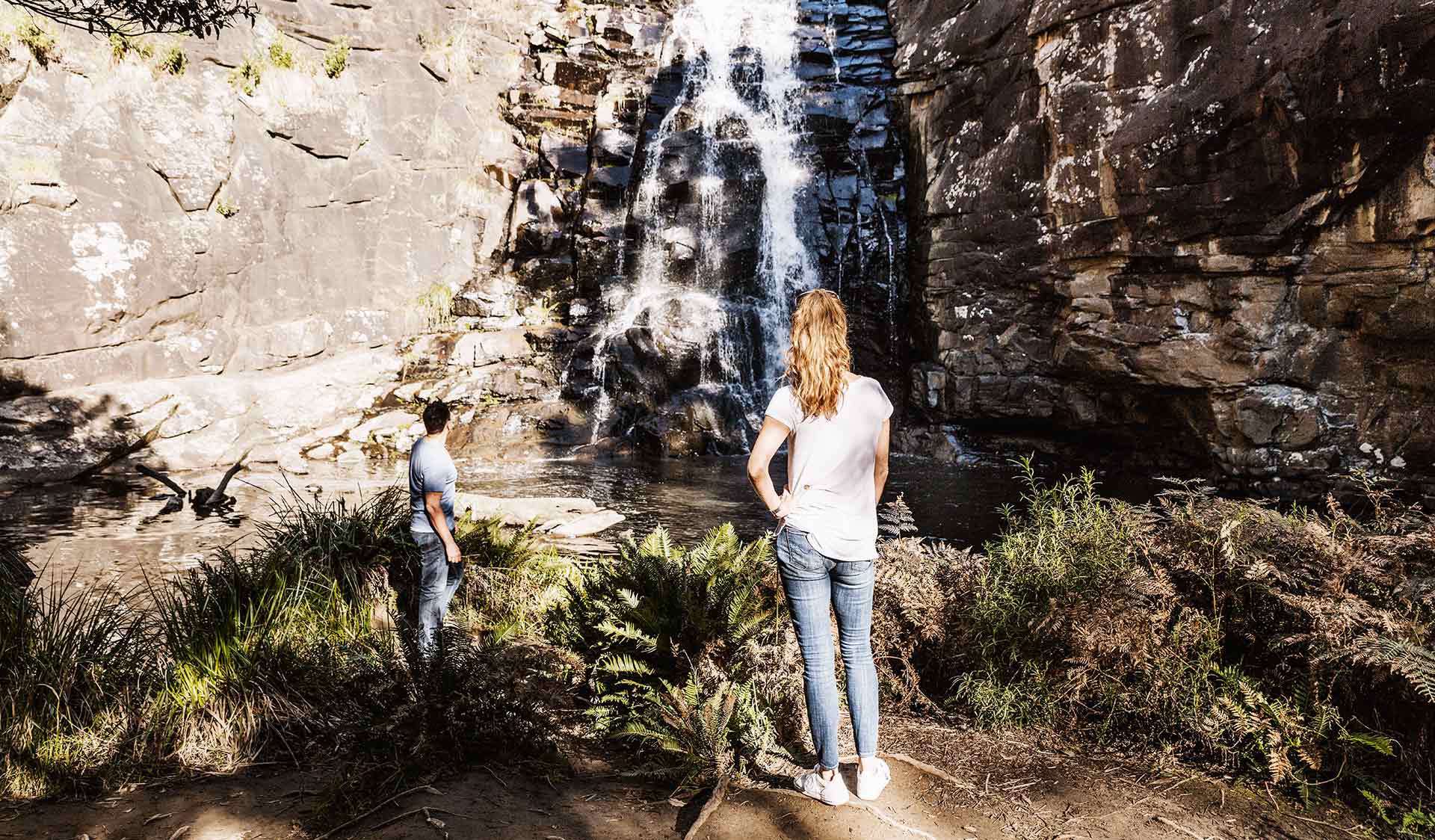A couple stand and admire Sheoak Falls near Lorne in the Great Otway National Park.