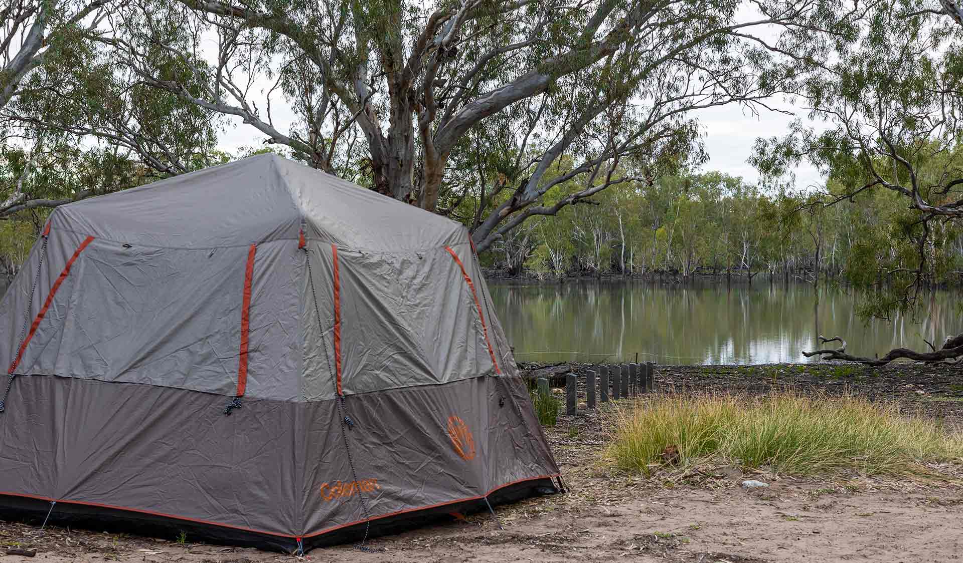 A large square grey tent pitched overlooking the water at Lake Hattah Campground at Hattah-Kulkyne National Park
