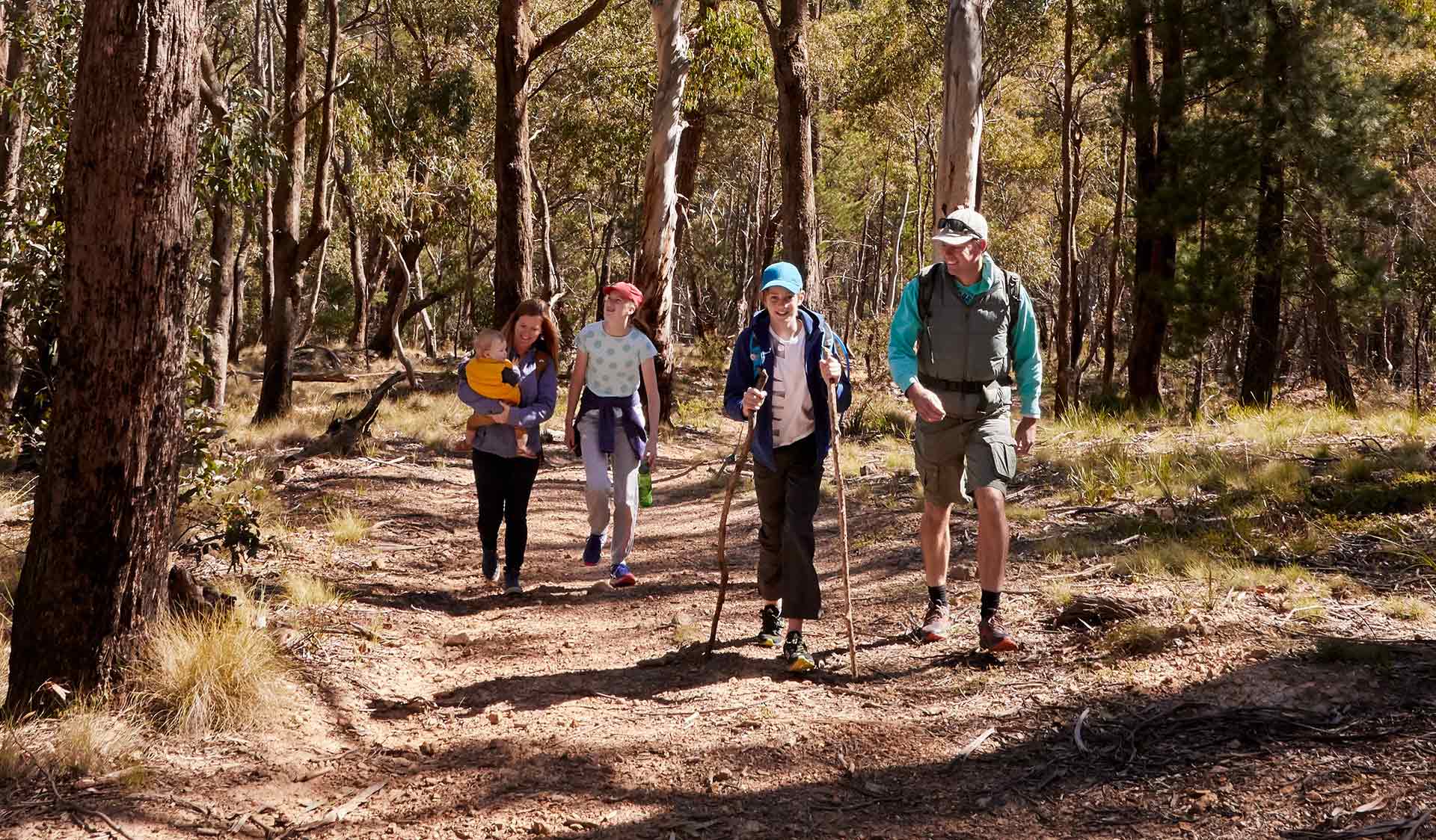 A husband and wife with their three children walk along Shaws Lake Track.