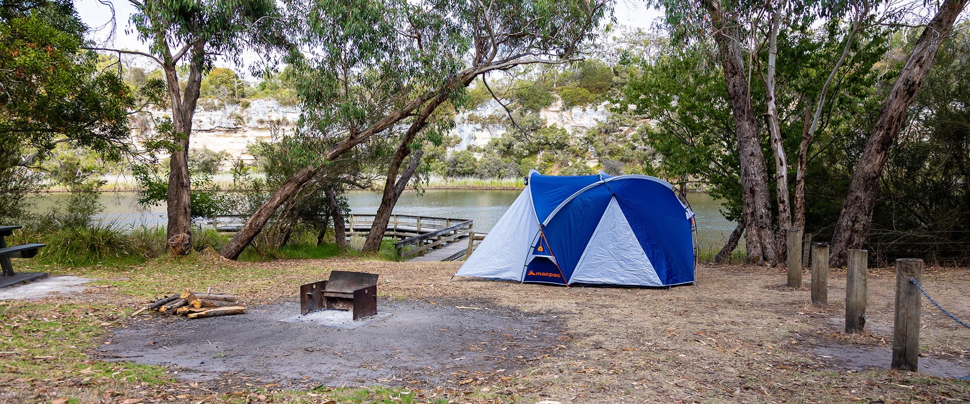 A fireplace in front of a large tent next to the river at Hutchessons Campground at Lower Glenelg National Park.
