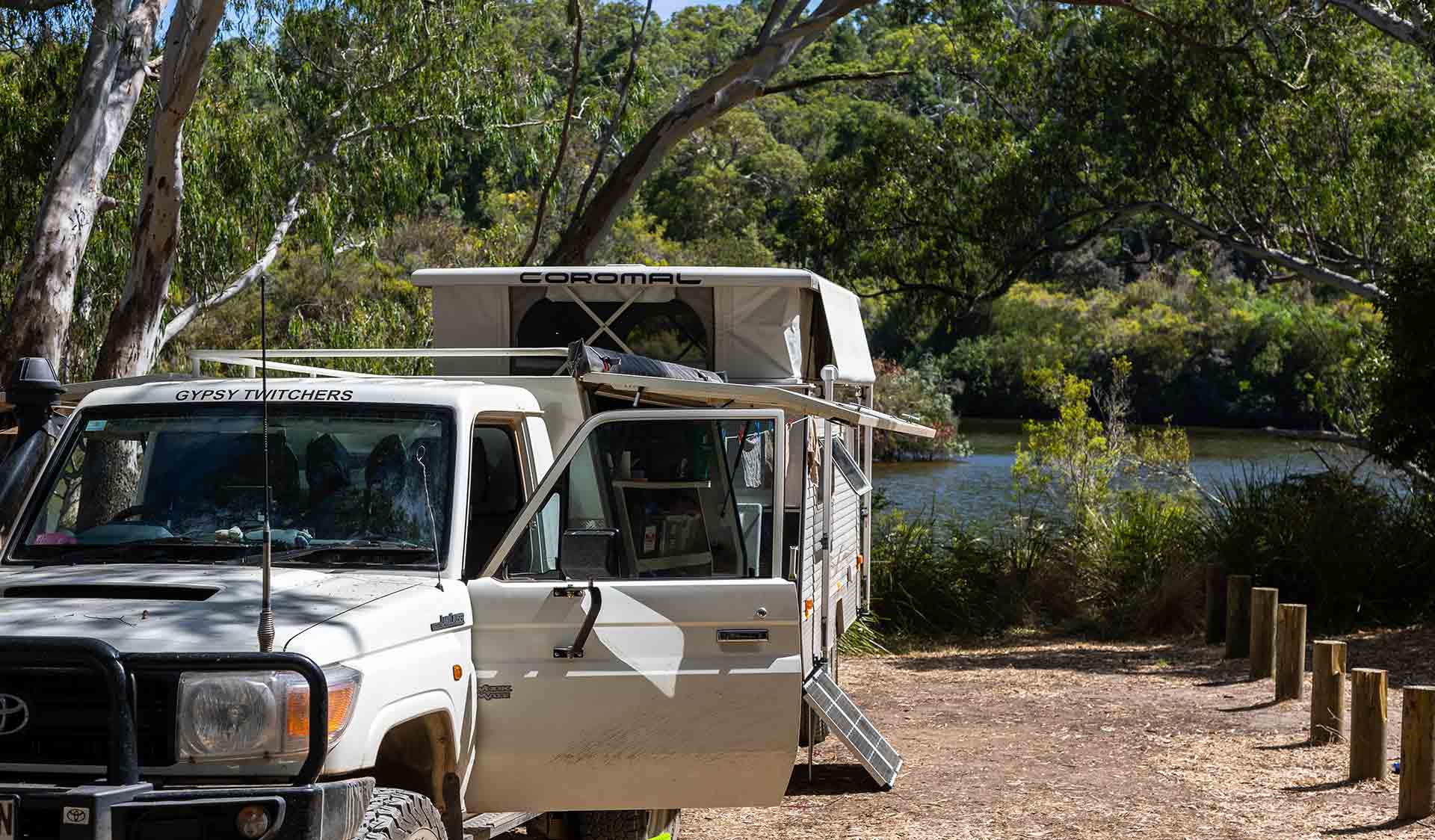 A 4WD with a camper trailer attached in front of the river at Red Gum Landing campground at Lower Glenelg National Park