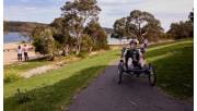A man hand cycles on a sealed path near Lysterfield Lake.