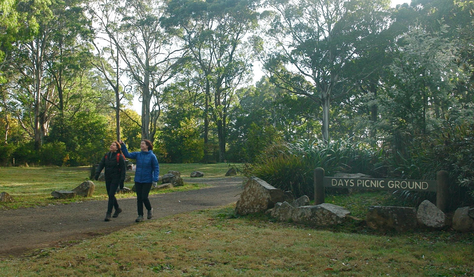 Two women walking along a path, with a Days Picnic Area sign in the foreground.