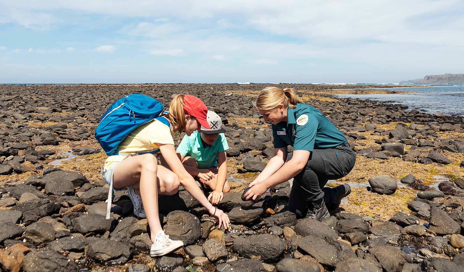 A young boy and girl looking at the marine life with a Parks Victoria ranger at Mushroom Reef