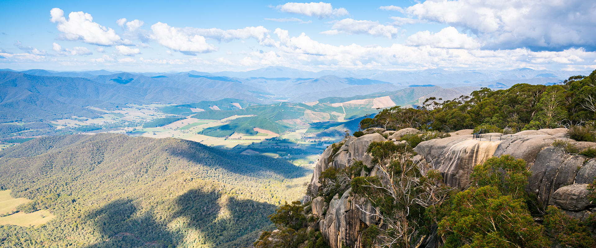 Granit rock slabs on the right hand side of the frame, in front of the valley below with views towards mountains in the background