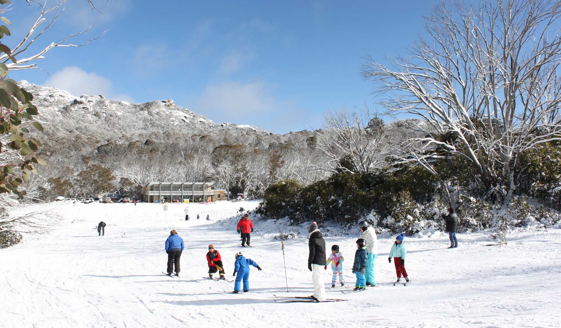 A family take a cross country skiing lesson at Dingo Dell at Mount Buffalo National Park