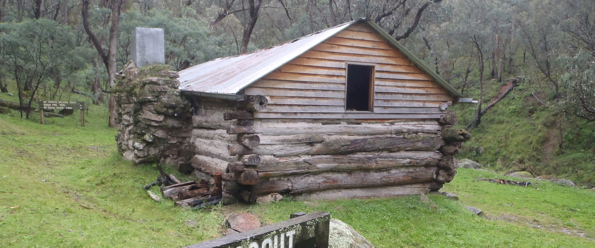 A historic hut set amongst a gassy hill in a green bushland